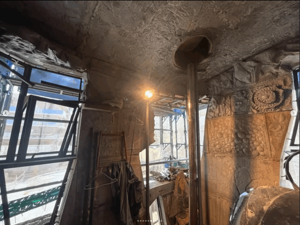 A creatively designed room showcasing textured, sculpted walls, large windows, and ambient lighting.